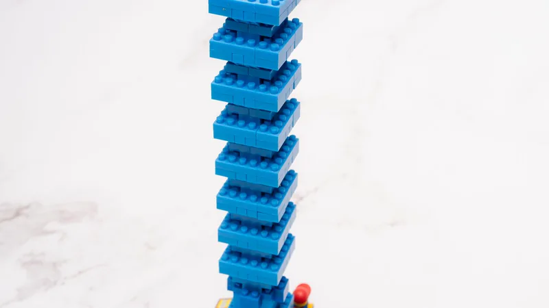 Hoher, leicht versetzter Turm aus blauen Klemmbausteinen auf hellem Marmor – Symbolbild für den Homepage-Baukasten