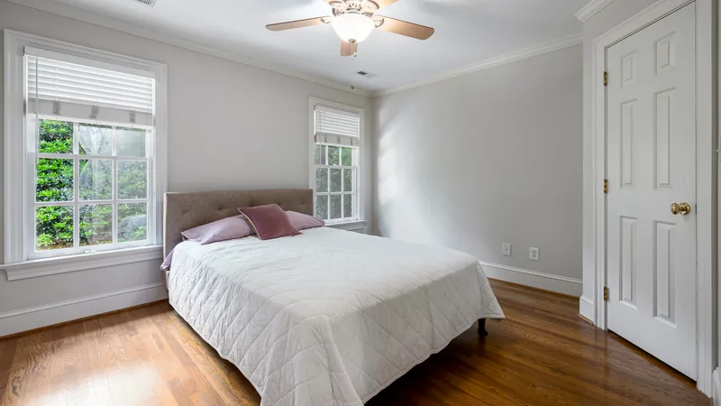 Helles, freundliches Gästezimmer mit weißer Bettwäsche und Blick ins Grüne – Symbolbild für eine einladende Ferienwohnung