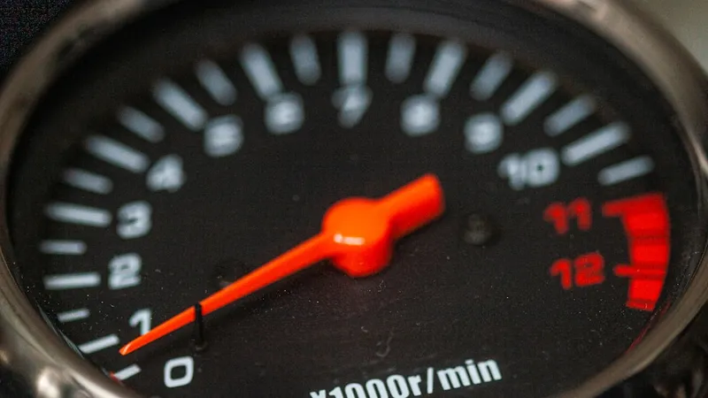 Tachometer-Nahaufnahme mit oranger Nadel – Symbolbild für Website-Geschwindigkeit und Performance
